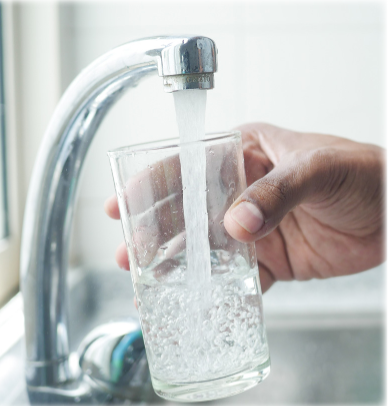 Glass being filled with water from faucet.
