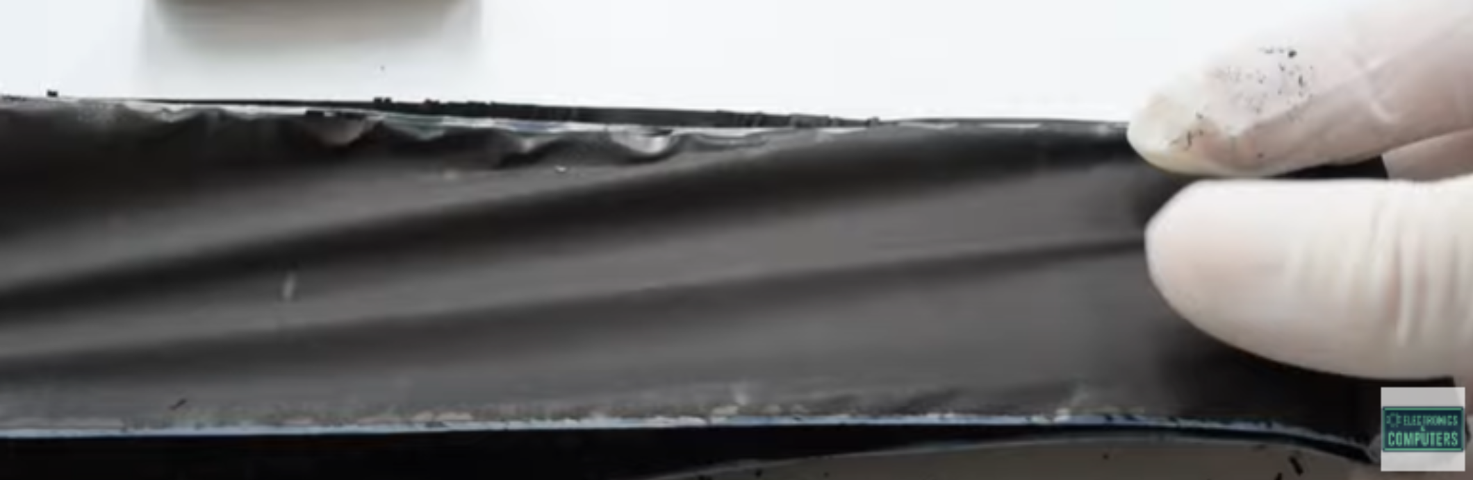 A rolled-up ribbon of black, flexible battery material