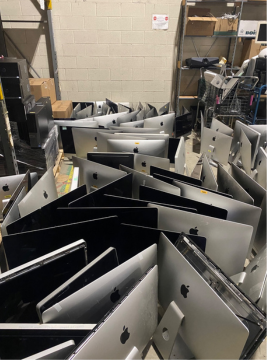 Dozens of Apple computers in a warehouse