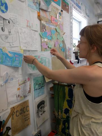Hanging up letters and pictures from children on the Ann Arbor office wall