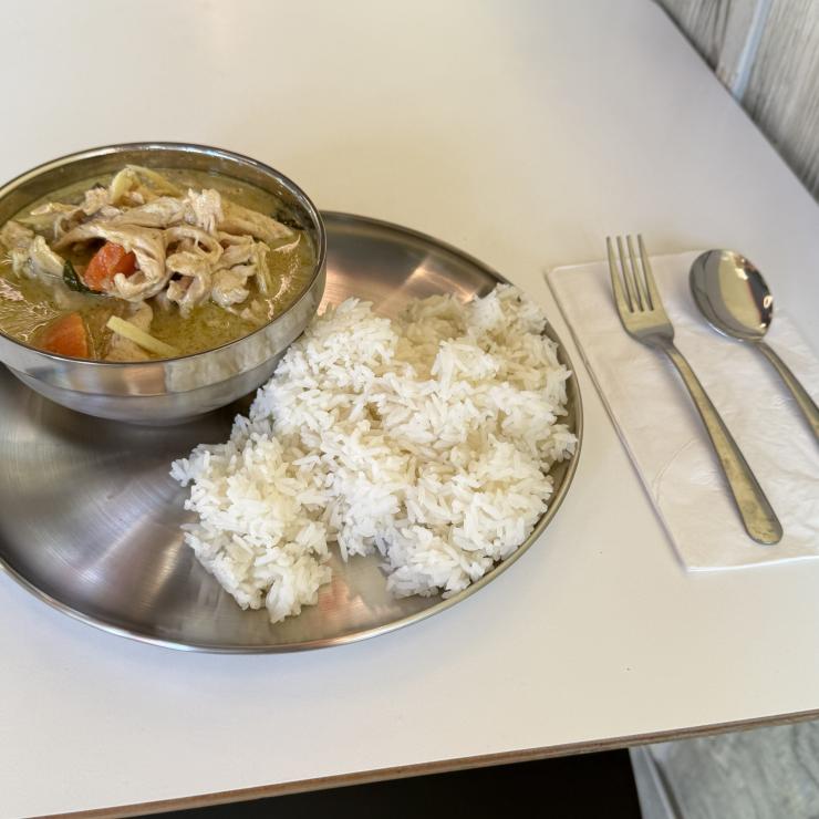 Stainless steel insulated bowls and metal utensils with thai food