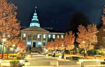 Maryland State House at night with blossoming trees and construction
