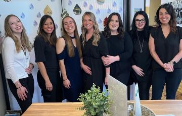 A photo of Clean Water Action's Bethany Dickerson with the staff of Serene Salon and Spa