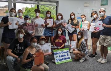 Clean Water Action staff posing with letters against the Line 5 pipeline