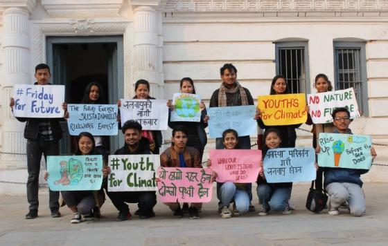 Image of People holding protest signs photo: Week 16 of Climate Awareness, Nepalese Youth for Climate Action team. The poster Chhimi Sherpa (bottom row, second from right) is holding is in Nepali and it translates to - Change the System, not the Climate (Date- Friday, 7th February 2020, Basantapur Durbar Square, Kathmandu) 