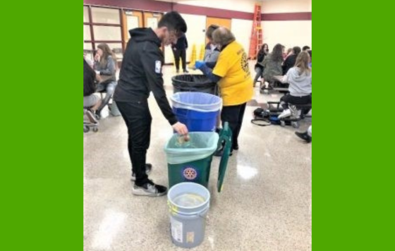 Text on a green background says "Back to School, Back to Zero Waste!" above and below a picture of students sorting their cafeteria waste into several different bins.